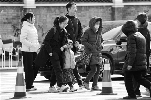 行人身穿羽绒服行走在北京街头 新华社发